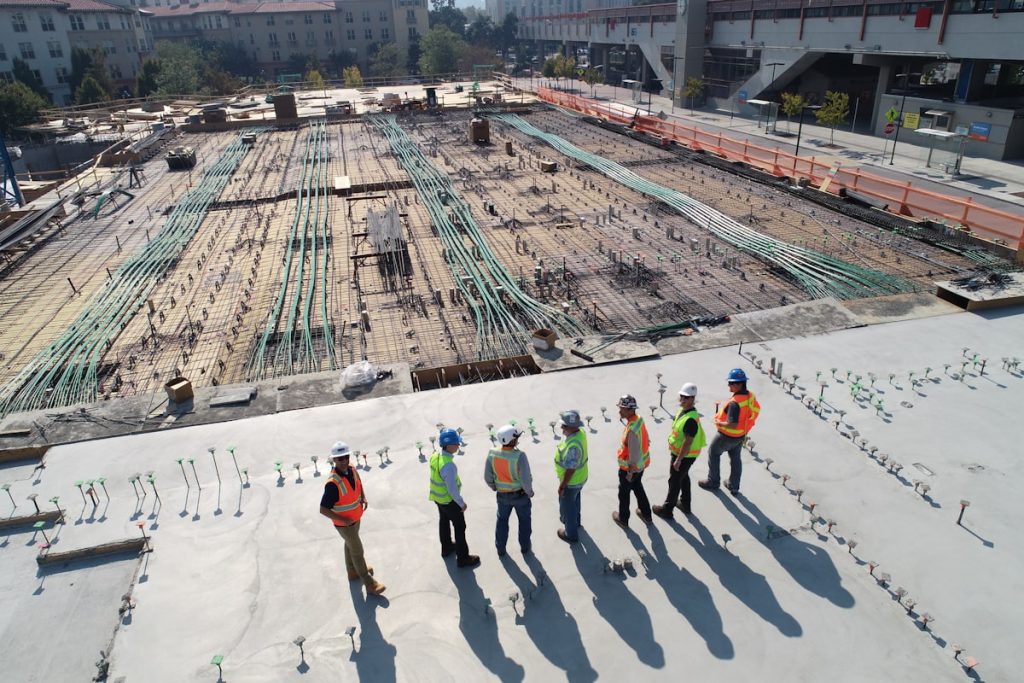 Construction workers in hard hats attending a site safety briefing