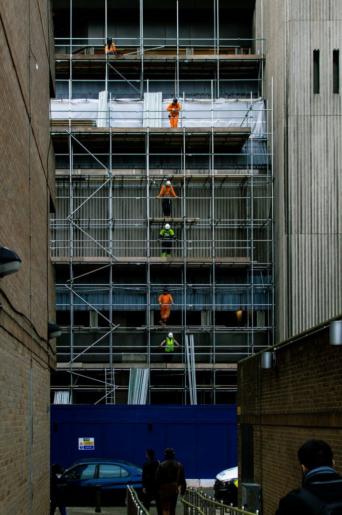 Construction workers on scaffolding at a UK building site