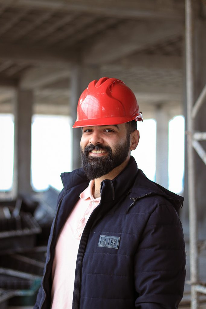 Construction worker wearing a red hard hat and jacket on a UK site